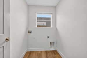 Laundry area featuring hookup for a washing machine, hookup for an electric dryer, and light wood finished floors