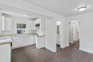 Kitchen featuring white cabinetry, granite countertops, lvp flooring