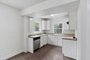Kitchen featuring white cabinetry, granite countertops, lvp flooring, dishwasher