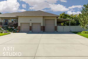 View of front facade featuring brick siding, concrete driveway, stucco siding, a gate, and a garage