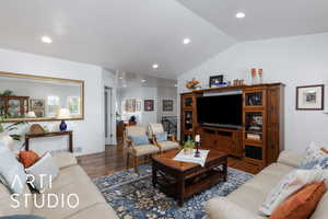 Living room featuring wood finished floors, vaulted ceiling, and recessed lighting