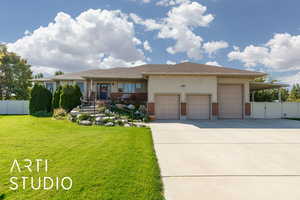 View of front of house with brick siding, concrete driveway, a garage, and stucco siding