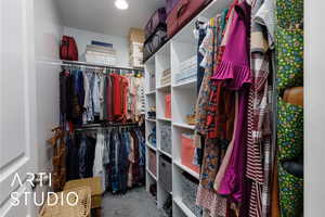 Walk in closet featuring light colored carpet