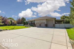 View of front facade with a gate, driveway, a carport, and a garage