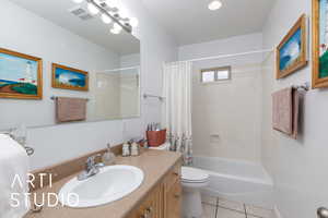 Full bath with shower / tub combo with curtain, vanity, light tile patterned floors, and recessed lighting