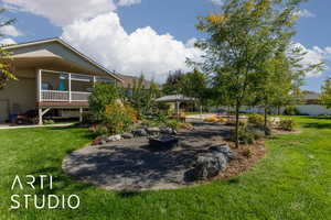View of green lawn featuring a fire pit and a patio area
