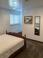 Bedroom with a textured ceiling and carpet flooring