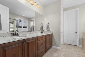 Full bath featuring double vanity, light tile patterned floors, and recessed lighting