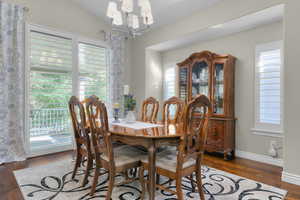 Dining room featuring dark wood-style floors and a chandelier
