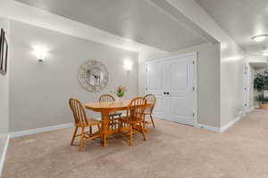Dining area with light colored carpet and a textured ceiling