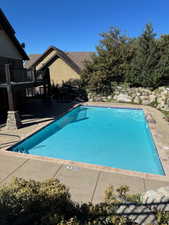 Community pool featuring a patio and a balcony
