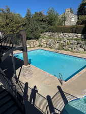 Community pool with a patio area and stairway