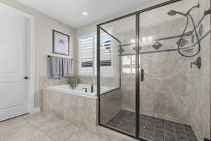 Bathroom featuring a stall shower, tile patterned flooring, a bath, and recessed lighting