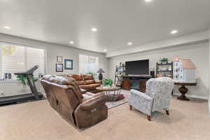 Living area featuring light colored carpet and recessed lighting