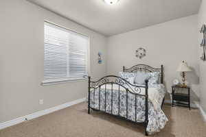 Bedroom with light colored carpet and baseboards