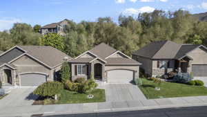 Craftsman inspired home with stone siding, concrete driveway, an attached garage, and stucco siding