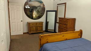 Bedroom with dark carpet and baseboards