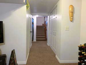Corridor with stairs and light carpet