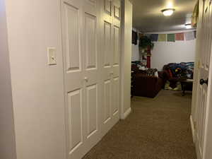 Corridor with carpet floors and a textured ceiling