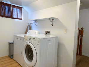 Washroom with washer and clothes dryer and baseboards