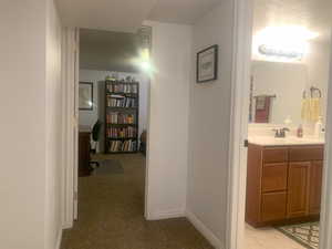 Hallway with light carpet and a desk