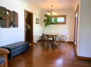 Dining space with dark wood finished floors and a chandelier