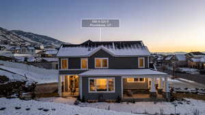 Snow covered rear of property featuring a residential view and a porch