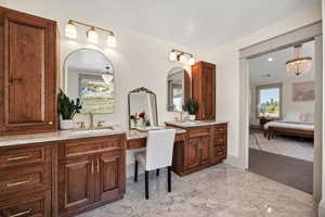 Bathroom with connected bathroom, two vanities, and a chandelier