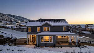 Snow covered house featuring a residential view and covered porch