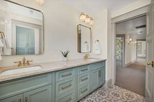 Full bath featuring double vanity and light tile patterned floors