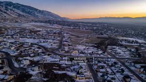 Snowy aerial view featuring a mountain view and a residential view