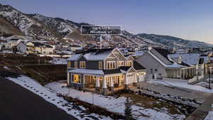 View of front of house with a mountain view, a garage, a porch, and a residential view