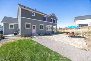 Back of house featuring a patio, a yard, an outbuilding, and outdoor dining area