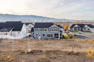 Rear view of house with a mountain view, a residential view, roof with shingles, and a chimney