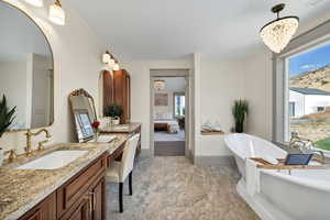 Bathroom with a chandelier, a freestanding bath, two vanities, ensuite bathroom, and a mountain view