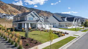 View of front of home with covered porch, a mountain view, a front lawn, and driveway