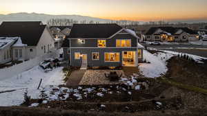 Snow covered property with a patio, a fenced backyard, a residential view, and a mountain view