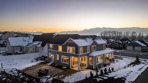 Snow covered property with a patio, a mountain view, and a residential view