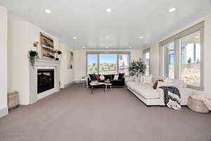 Living area featuring a glass covered fireplace, light carpet, and recessed lighting