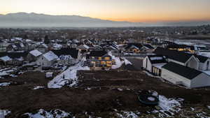 Snowy aerial view featuring a residential view and a mountain view