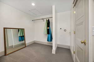 Walk in closet with carpet floors and attic access