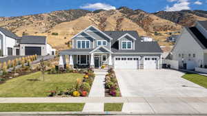 Craftsman house with stone siding, a porch, and a mountain view