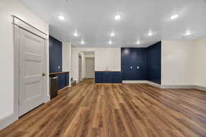 Spare room with dark wood-style floors, recessed lighting, and stairs