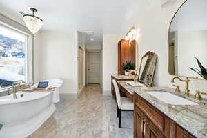 Full bath featuring double vanity, a soaking tub, a shower stall, and a chandelier