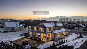 Snow covered back of property featuring a patio area, a mountain view, and a residential view