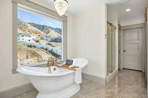 Bathroom with a shower stall, a freestanding bath, a chandelier, recessed lighting, and a mountain view