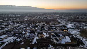 Snowy aerial view featuring a mountain view and a residential view