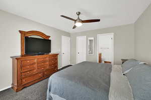 Bedroom featuring carpet, a ceiling fan, connected bathroom, and a textured ceiling