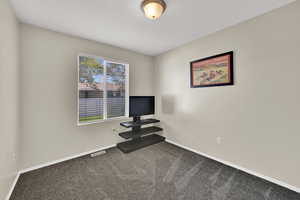 Bedroom with baseboards and dark carpet