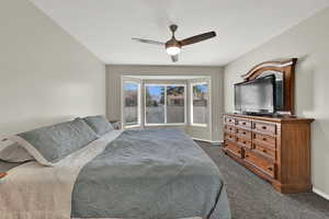 Bedroom featuring carpet flooring, a ceiling fan, and a textured ceiling